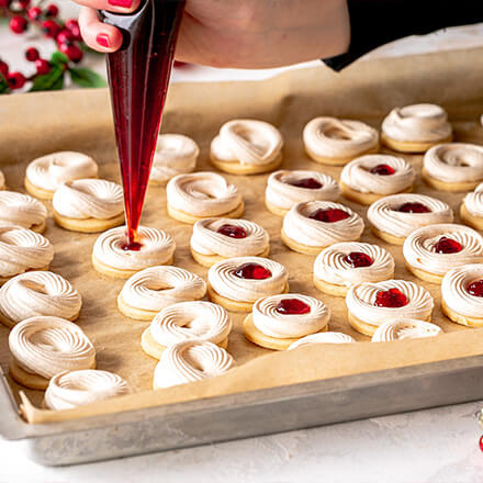 Blog Beitrag Weihnachtsplätzchen Step3 Marmelade in ein Spritzbeutel füllen und anschließend in die Mitte der Eisschneekreise befüllen.