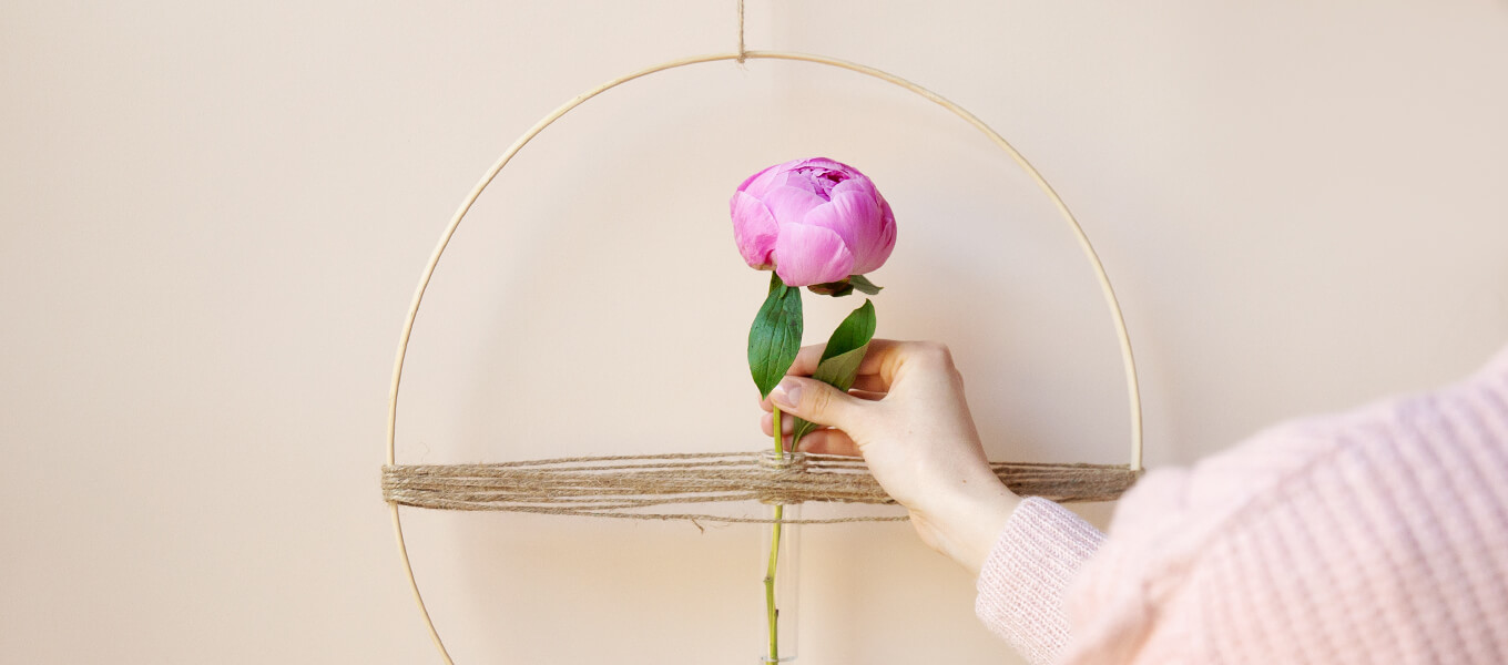 DIY-Blumenring mit Reagenzglas und Pfingstrose Frau steckt eine Pfingstrose in einen DIY-Blumenring mit Reagenzglas