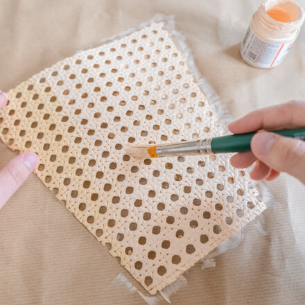 Flower-Bag-Upcycling-Idee zur Geschenkbox: Step 4 Wiener Geflecht wird auf einer Pappunterlage mit Hilfe eines Pinsels und Acrylfarbe in einem zarten Rosé-Beige bemalt.