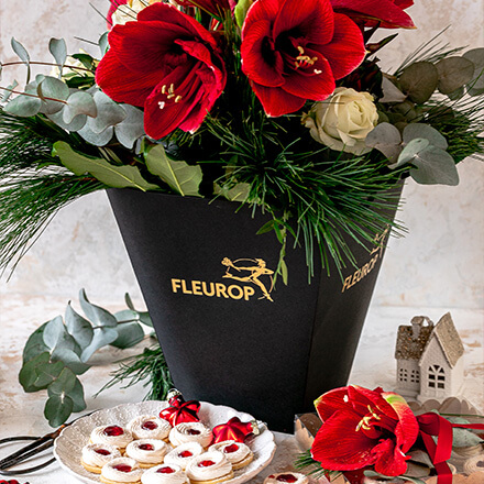 Blog Beitrag Weihnachtsplätzchen Weihnachtsplätzchen stehen vor einer Flower_Bag mit einem Amaryllisstrauß.