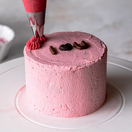 Valentinstag-Torte: Torte mit Cremetupfen umranden Torte wird mit restlicher Creme verziert