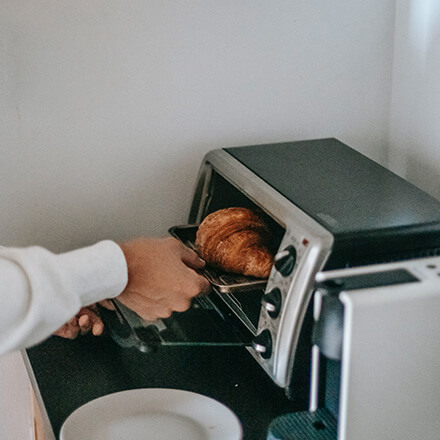 Warme Croissants Croissant wird im Wärmegerät erwärmt