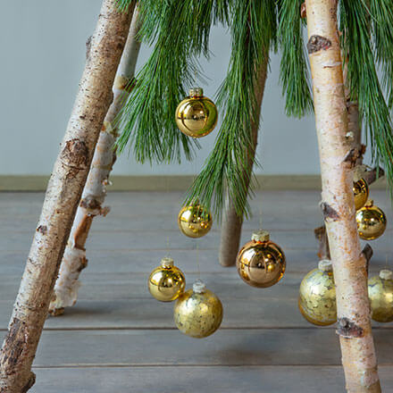 Blog Beitrag Alternativ Weihnachtsbaum Step3 Nun werden Weihnachtskugeln mithilfe von Draht an die Kieferzweige befestigt.