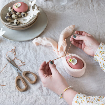 Osterdeko: Tischdeko zu Ostern selber machen: Step 4 Serviette wird mit einem Lederband um dem bemalten Ei fixiert