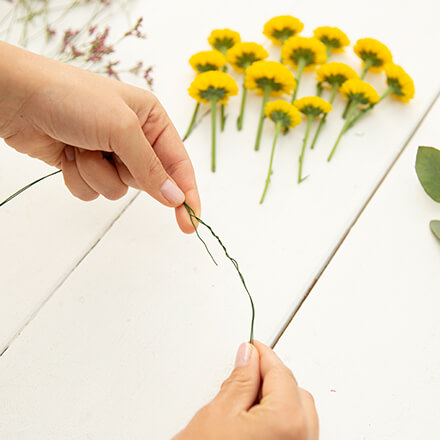 DIY: Haarkranz selbst basteln - Step 1: Draht abmessen Zwei Hände biegen einen Draht zu einem Kreis. Die zwei Enden werden miteinander verdreht.