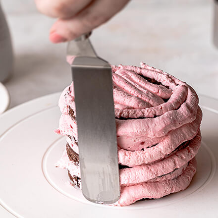 Valentinstag-Torte: Creme glattstreichen Himbeercreme wird glattgestrichen