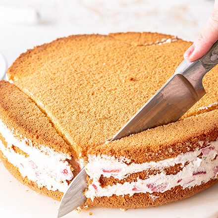 Erdbeerherz-Torte backen: den Kuchen zuschneiden Kuchen wird in Herzform geschnitten