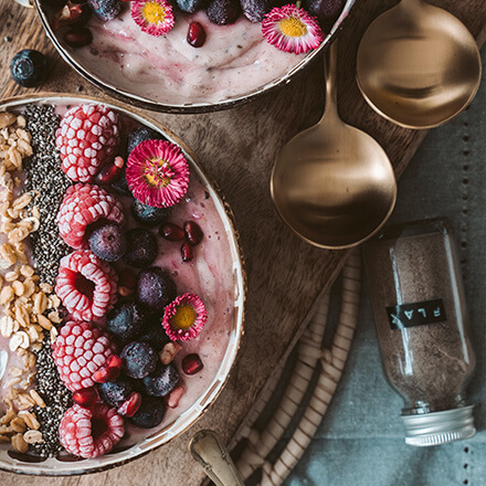 Frühstücksbowl mit Himbeeren Frühstücksbowl in rosa mit Himbeeren und Walnüssen