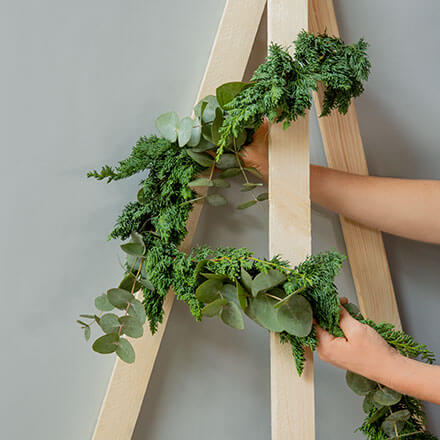 Blog Beitrag Alternativ Weihnachtsbaum Step6 Die Girlande wird nun um die Holzlatten an den Nägeln entlang befestigt.