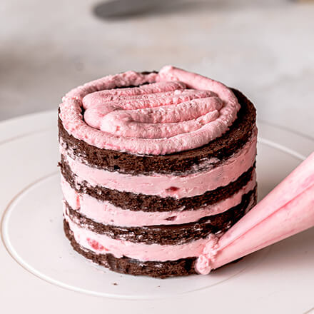 Valentinstag-Torte: Törtchen mit Creme umspritzen Torte wird mit Himbeercreme umspritzt