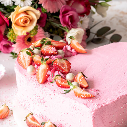 der fertige Kuchen in Herzform, dekoriert mit Erdbeeren
