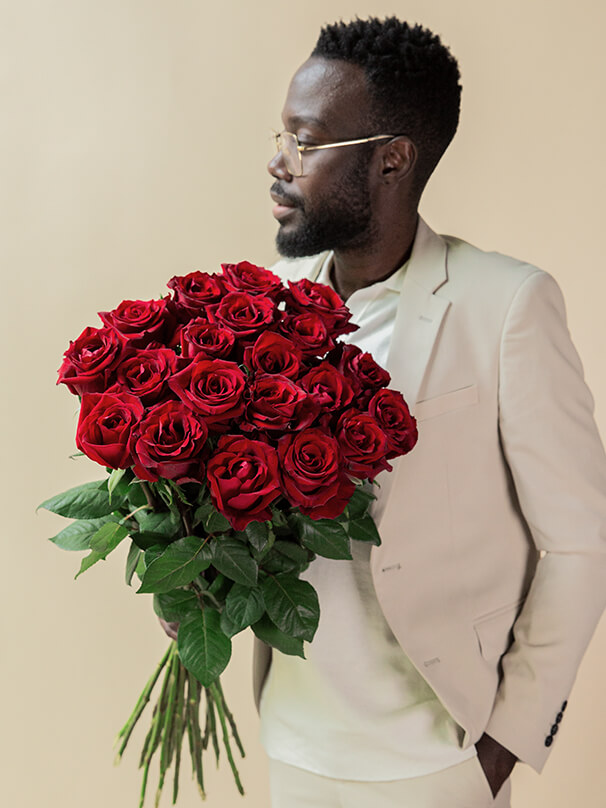 Mann hält großen Strauß rote Rosen