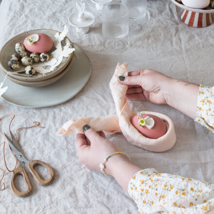 Osterdeko: Tischdeko zu Ostern selber machen: Step 3 gefaltetete Stoffserviette wird um das bemalte Ei gelegt
