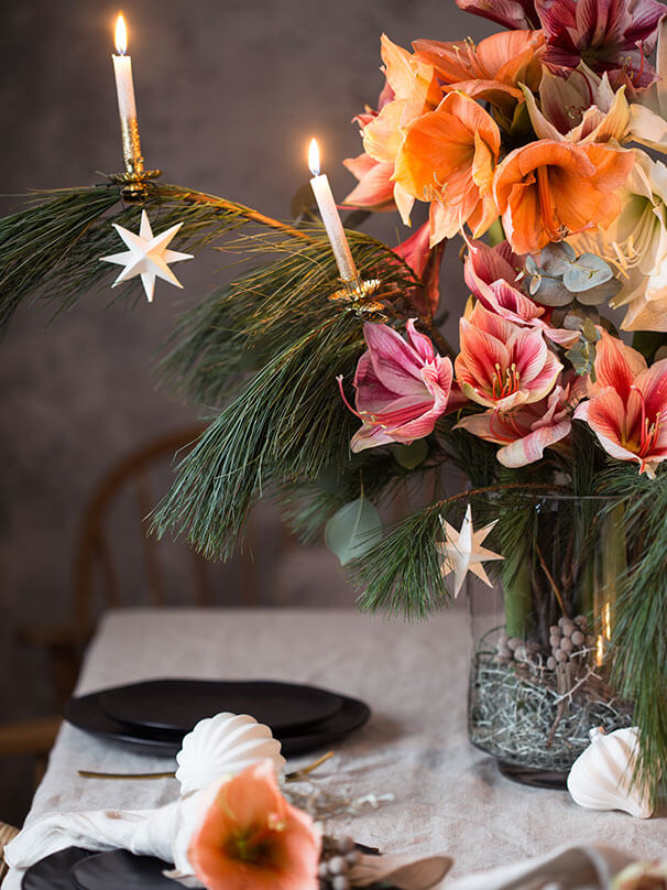 dekorierter Weihnachtstisch mit Amaryllis und Kerzen