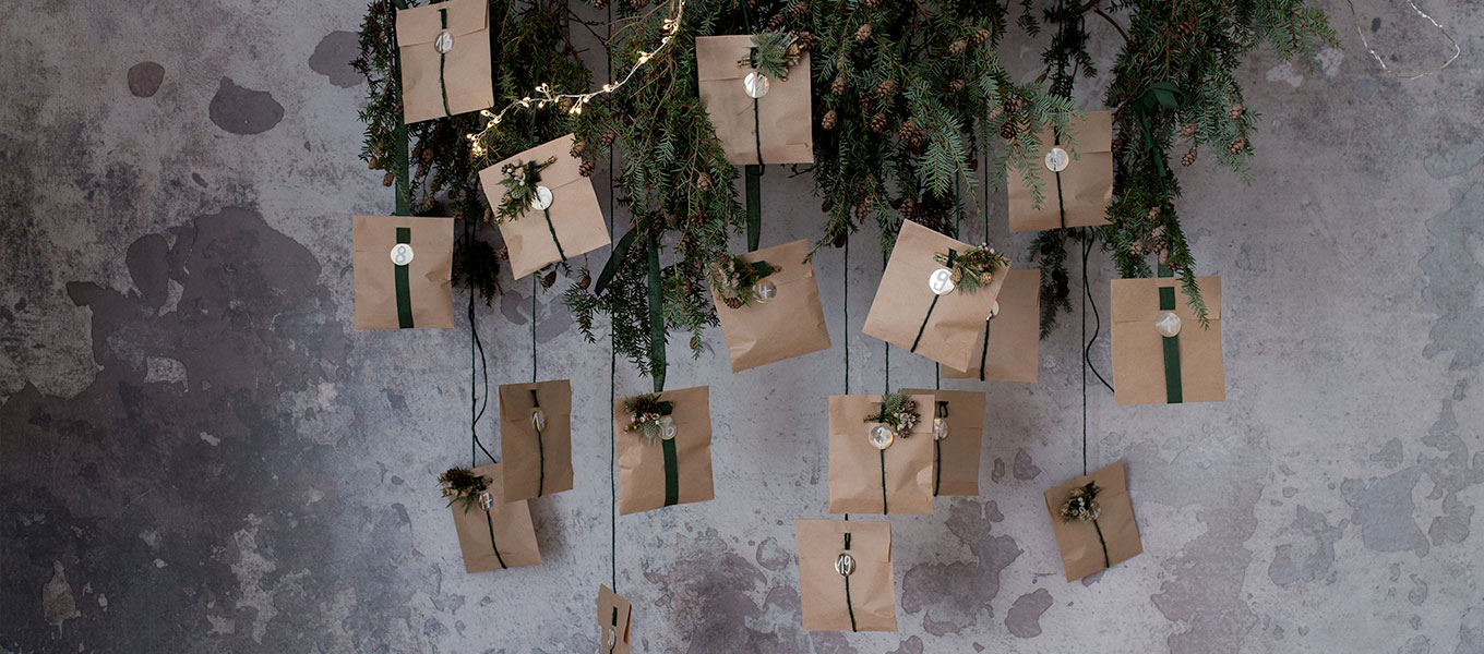 Adventskalender selber machen Der fertige DIY Adventskalender hängt an einem Deko Tannenzweig