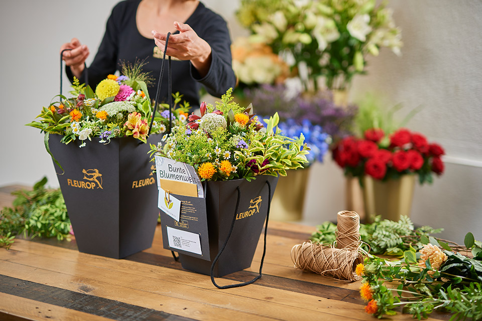 Fleurop Floristin Flower Bag Floristin mit FlowerBag auf dem Tisch