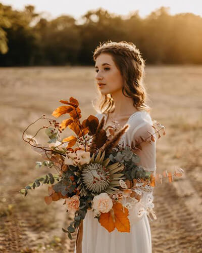 Braut hält einen Blumenstrauß im Natur Look