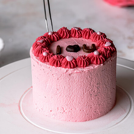 Valentinstag-Torte: Törtchen verzieren Torte wird mit Streuseln dekoriert