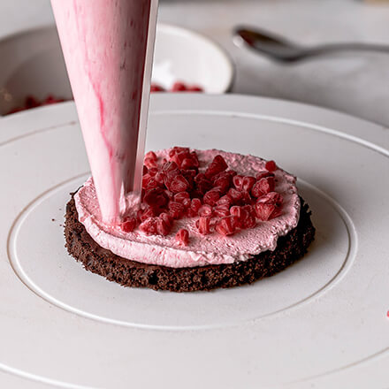 Valentinstag-Torte: Creme auf Himbeeren geben Himbeercreme wird aufgetragen
