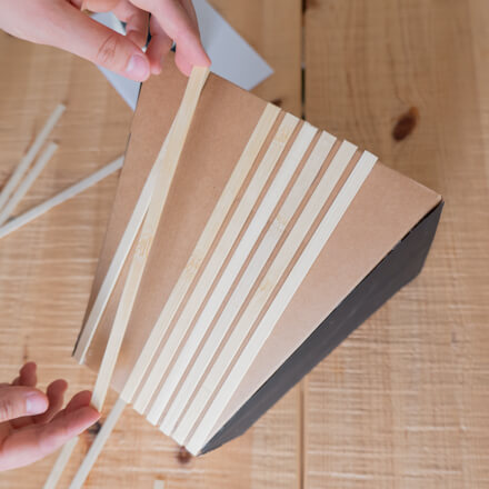 Flower-Bag-Upcycling-Idee zur Vase: Step 5 Zugeschnittene Stäbe aus Bambus werden senkrecht an den Seiten der Flower-Bag befestigt.